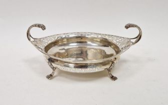 Silver shallow bowl with scroll pierced everted rim, pair of foliate free scroll handles on four paw