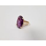 Gold-coloured metal and large amethyst-coloured stone ring set single oval faceted stone (marked