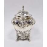 Victorian silver tea caddy with domed top, shouldered and tapering with floral repousse, four paw