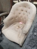 Early 20th century buttonback armchair raised on front turned legs, 81cm high