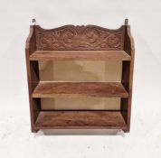 Carved oak hanging bookshelf having three tiers with scrolling carved foliate motifs to the side and
