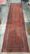 Eastern style red ground runner with one row of 18 elephant foot guls, multiple geometric borders,