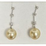 Pair of 14K white gold, diamond and pearl drop earrings, the beige pearl drops suspended from