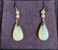 Pair opal and diamond white metal drop earrings, each with two collet-set diamonds and teardrop-