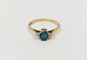 9ct gold, blue stone and diamond three-stone ring, the oval mid-blue-coloured stone flanked by two
