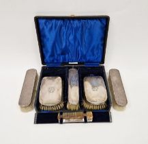 Cased George V silver mounted vanity set, comprising three brushes and one comb, hallmarked