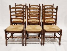 Set of six oak antique ladderback dining chairs, each with removable wicker seat bases, raised on