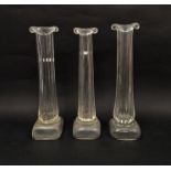 Three Patrick Stern clear glass vases in the form of columns on plinth bases, each signed to base,