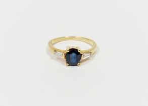 18ct yellow gold, sapphire and diamond ring set oval sapphire flanked by two tapering baguette-