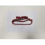 String of red amber-coloured graduated oval beads Condition Report Some beads with light surface