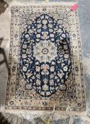 Persian blue ground handmade wool, cotton and silk 'Nain' rug with central floral medallion on woven
