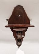Carved mahogany wall bracket with rectangular shelf above foliate scroll and leaf support, on shaped