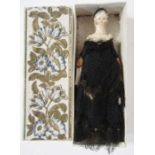 19th century carved and painted peg doll wearing a period black dress, 8cm long, housed in a small