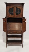 Late 19th/early 20th century Arts and Crafts oak escritoire, comprising a glazed two door cupboard