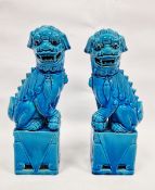Pair of Chinese Kangxi-style turquoise-glazed models of lion dogs, 20th century, each modelled