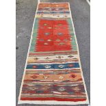 Kilim gallery carpet, woven with stylised geometric foliate motifs, on a striped ground, in red,