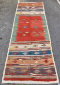 Kilim gallery carpet, woven with stylised geometric foliate motifs, on a striped ground, in red,