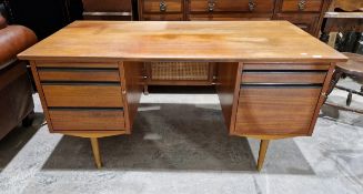 Mid-century teak desk, the central recess flanked by writing slide and three graduating drawers, the