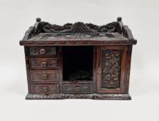 Stained wooden table-top cabinet, the outer decorated with carved geometric and floral motifs