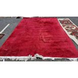 Contemporary deep red-pink ground carpet, probably Chinese Superwash, decorated with scrolling