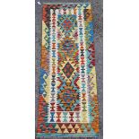 Chobi kilim runner, woven with geometric lozenges in red, blue, green, ochre and yellow within