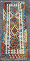 Chobi kilim runner, woven with geometric lozenges in red, blue, green, ochre and yellow within