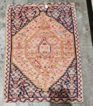 Small North West Persian rug, woven with a pink, ochre and red lozenge-shaped medallion reserved