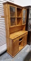 20th century pine dresser, the top section having two glazed cupboard doors opening to reveal two