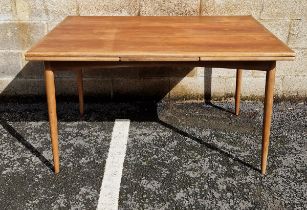 Mid-century teak draw-leaf dining table, of rectangular form, on rounded tapering legs, possibly