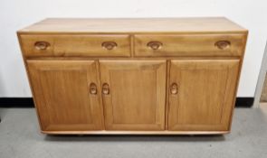 Ercol light elm 'Windsor' sideboard, having two drawers above a three cupboard doors, the right side
