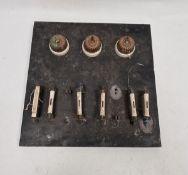 Early 20th century slate mounted panel of switches and ceramic fuses, with three gilt metal jelly-