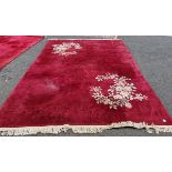 Contemporary Chinese superwash red ground carpet decorated with flowers and prunus, within fringed