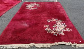 Contemporary Chinese superwash red ground carpet decorated with flowers and prunus, within fringed