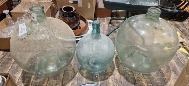 Two large and two smaller glass carboys, 54cm x 50cm x 43cm and 32cm high respectively (4)