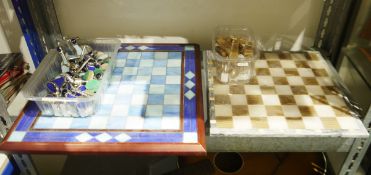 Two modern chess sets, one with pale blue chess board with silver-coloured metal and coloured