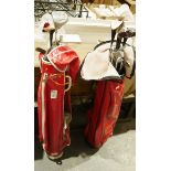 Two sets of golf clubs in red carry cases