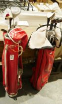 Two sets of golf clubs in red carry cases