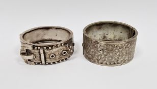 Victorian silver buckle pattern bangle and another white metal bangle, foliate engraved (2)