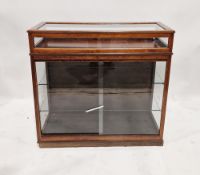 A twentieth century stained wooden collectors display cabinet, having a hinged top and sliding two