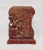 Asian carved and red stained/lacquered wood mythical beast, of shaped rectangular form, carved