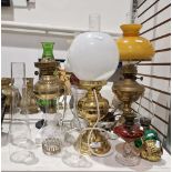 Collection of early 20th century oil lamps and fittings including three brass/gilt metal examples,