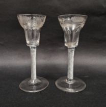 Two mid-18th century engraved airtwist wine glasses, each pan topped example engraved, the first