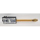 Novelty numberplate box guitar, the numberplate inscribed 'Quebec ZXD 506 Je me Souviens', 85cm long