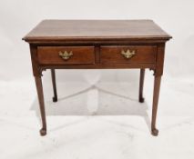 A Georgian oak lowboy of rectangular form with two short drawers to the front, each with brass