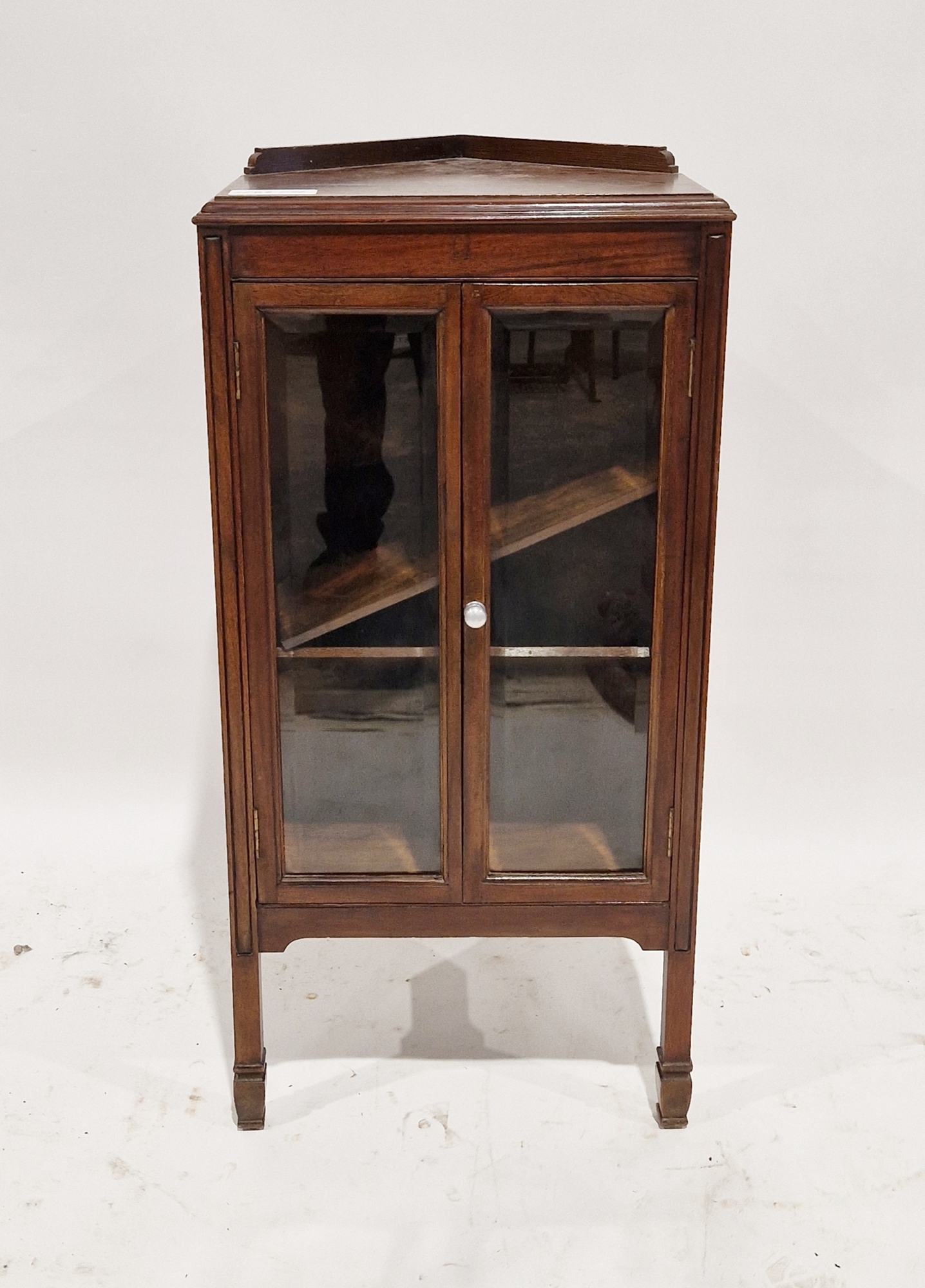Reproduction stained wooden corner cabinet, the two bevelled edge glass doors opening to reveal