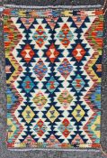 Chobi kilim, woven with geometric lozenges in red, blue, ochre, manganese against a cream ground,