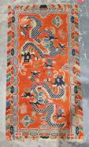 Pair of Chinese style rugs, possibly Tibetan, the central panel with two dragons chasing flaming