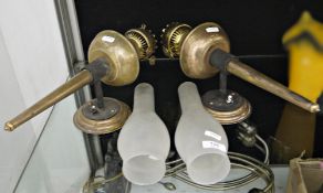 Pair of early 20th century brass wall lights, each of torch oil lamp form with burner and frosted