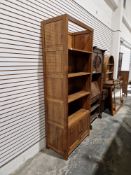 20th century hardwood storage unit comprising three adjustable shelves over a two-door cupboard,