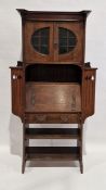 Late 19th/early 20th century Arts and Crafts oak escritoire, comprising a glazed two door cupboard